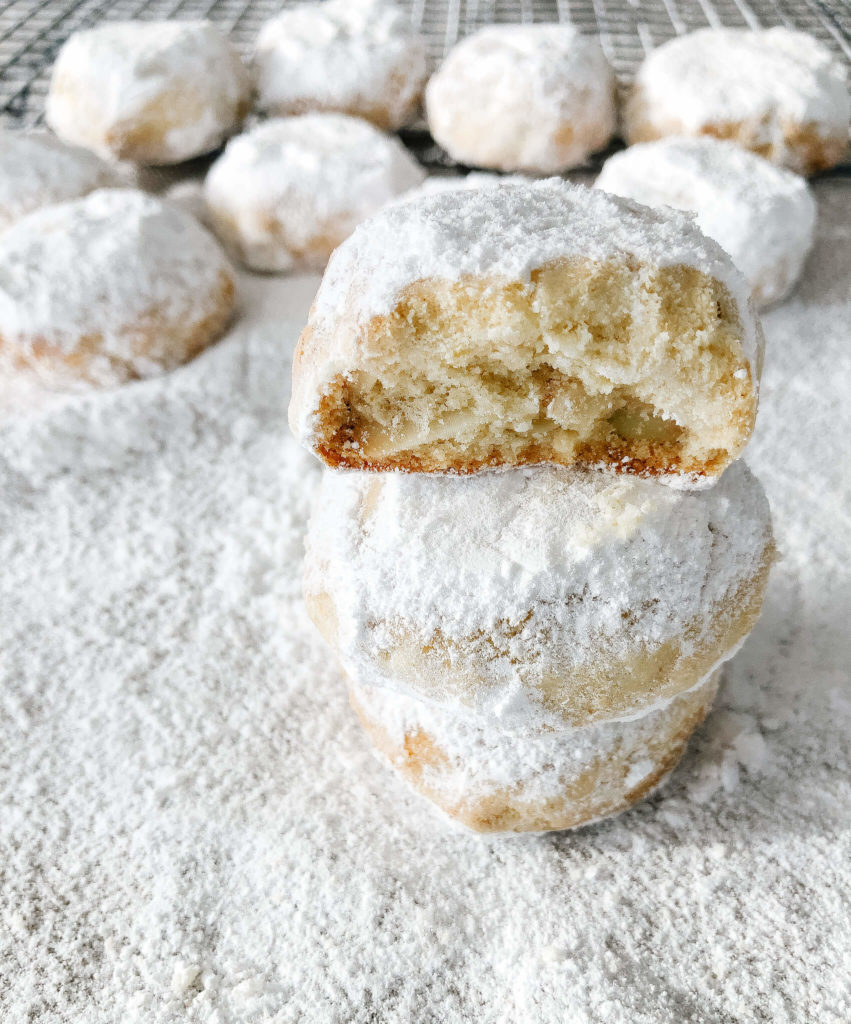 three greek almond cookies sprinkled with icing sugar