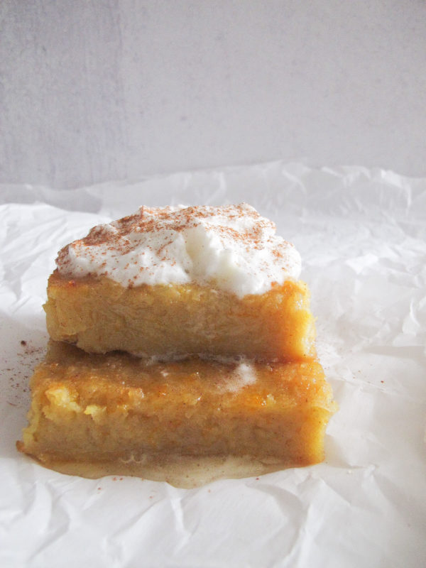 Two pieces of greek orange cake with whipped cream and cinnamon powder