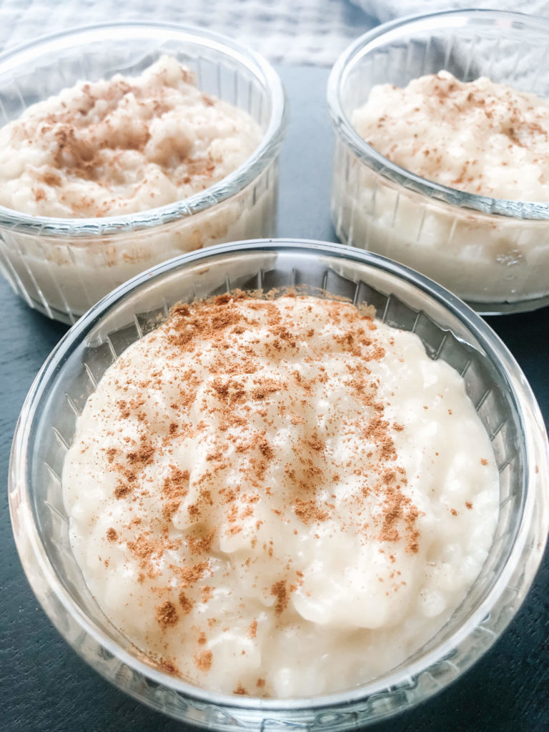 cooked rice pudding sprinkled with cinnamon in a small glass bowl