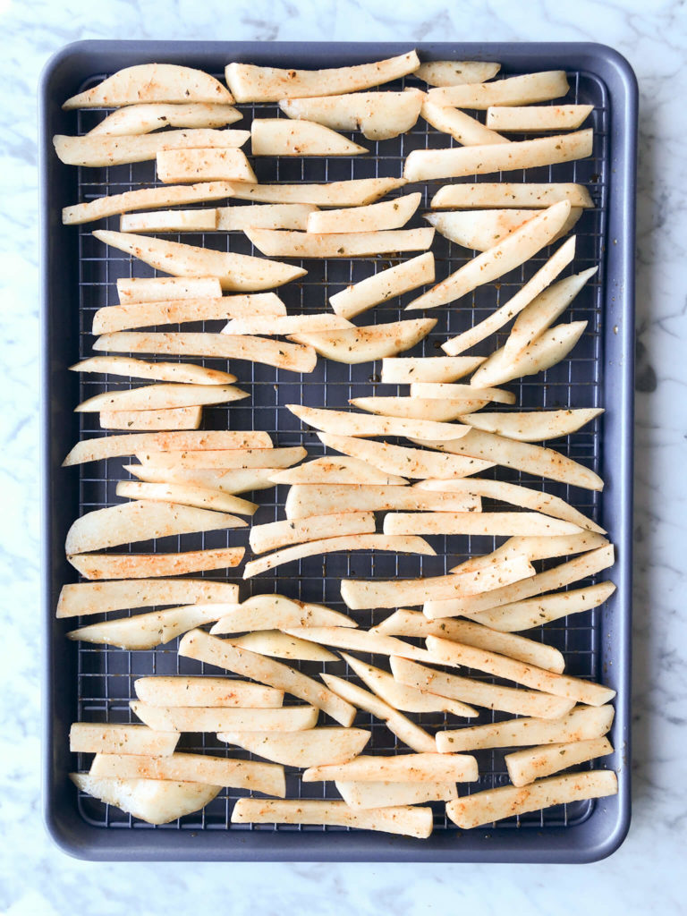 sliced uncooked homemade fries on a baking sheet