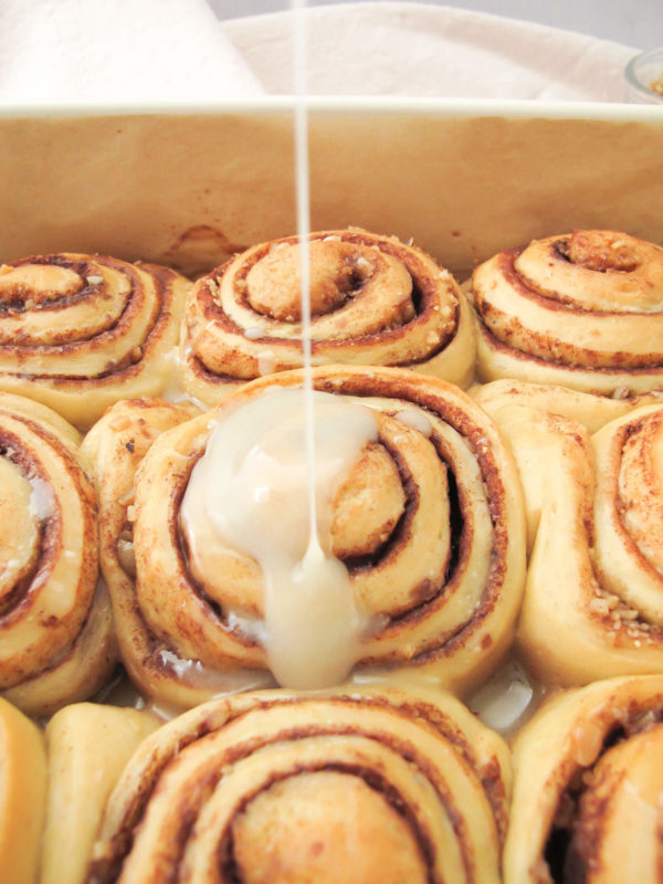 vanilla honey icing poured over baklava cinnamon rolls