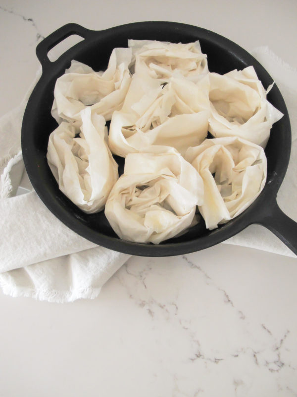 rolled raw phyllo sheets in a circle in a 10" cast iron skillet