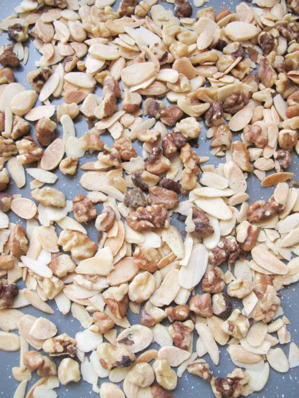 walnuts and blanched almonds on a baking sheet