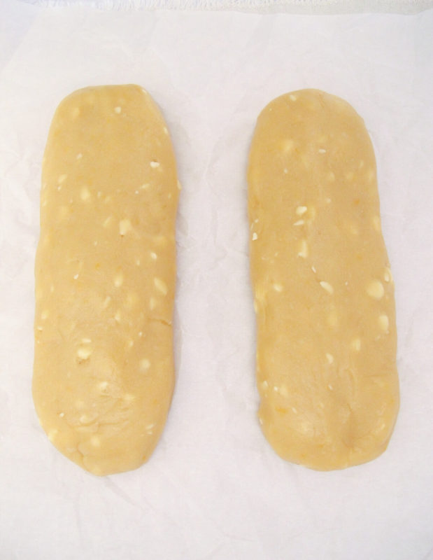 two lemon biscotti dough loaves side by side on parchment paper.