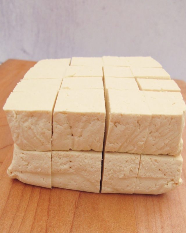 A block of tofu sliced in half and then cut into 32 pieces.