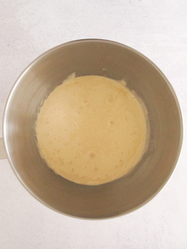 whisked eggs with white sugar in a mixing bowl.