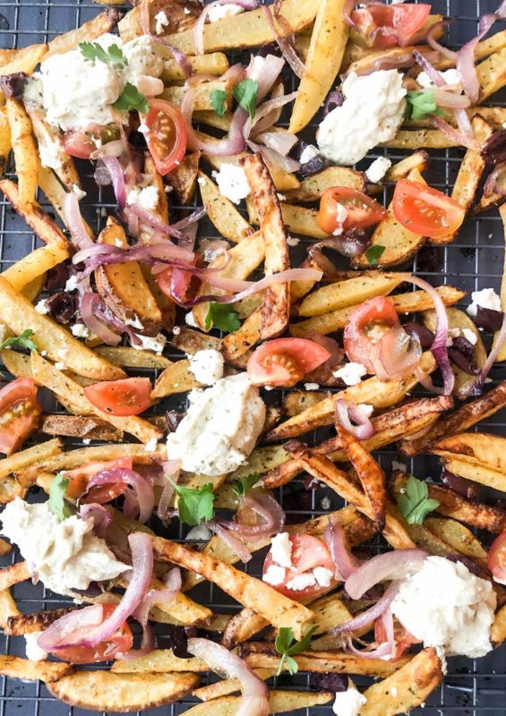 oven baked greek fries with crumbled feta cheese, caramelized red onions, diced tomatoes, and tzatziki.