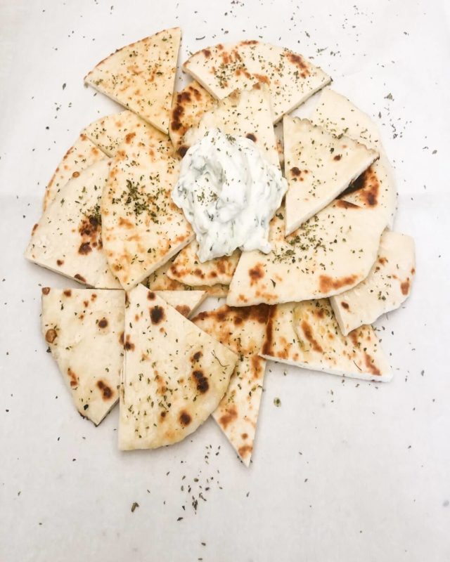 pita bread triangles with oregano and tzatziki dip.