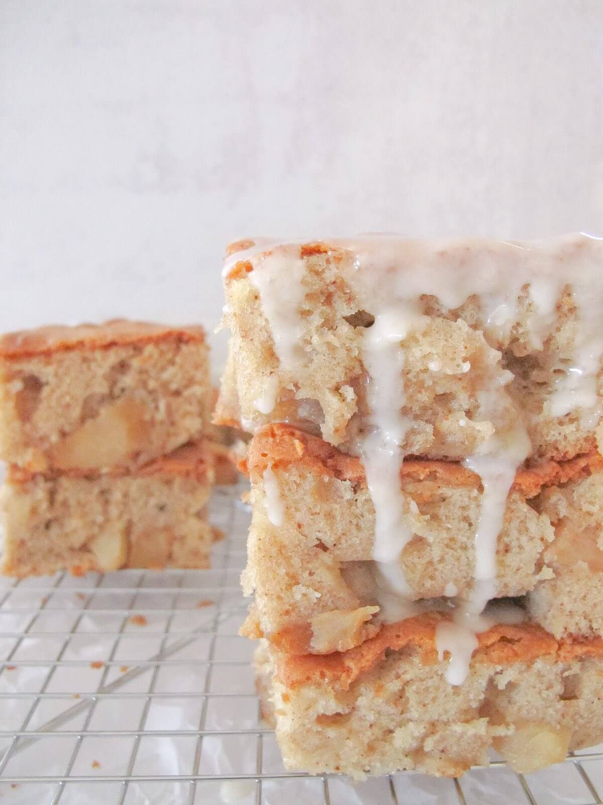 Three pieces of apple cake stacked on top of each other and topped with icing sugar.