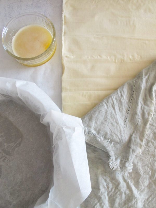 phyllo sheets, melted butter, and a baking dish with parchment paper.