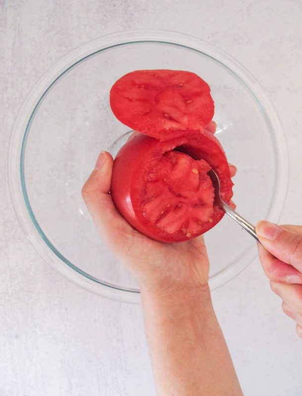 removing the flesh of the tomatoes with a spoon.