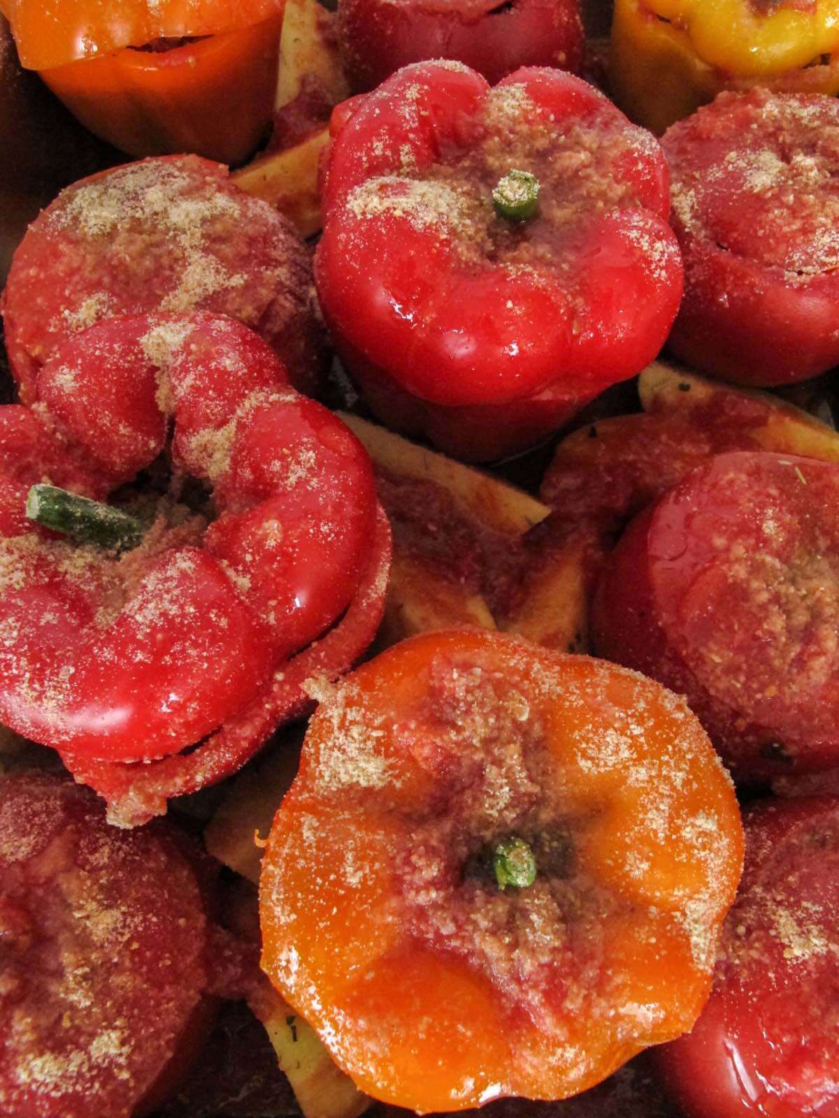 bell peppers and tomatoes in a baking dish with breadcrumbs on top.