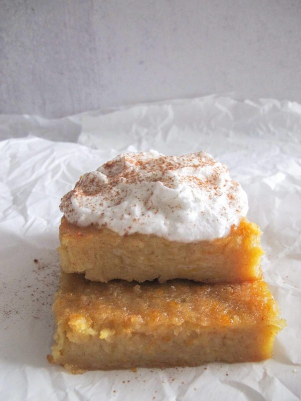 two pieces of greek orange cake topped with whipped cream.