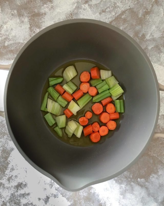 Chopped celery and carrots in a pot with olive oil.