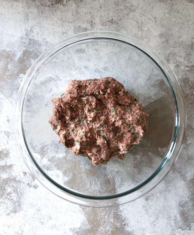 Youvarlakia ground beef mixture in a large glass bowl.