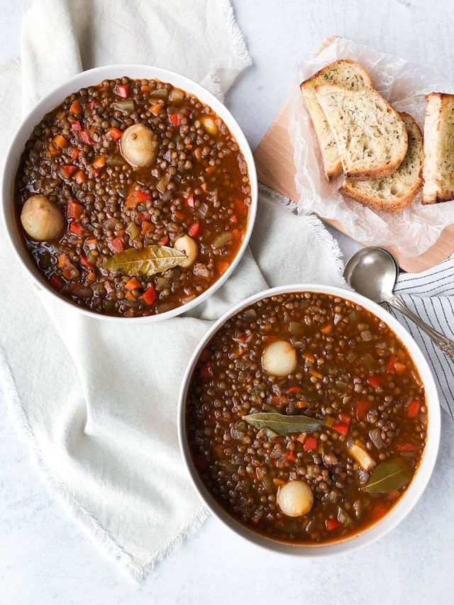 two bowls of lentil soup in white bowls with toasted bread.