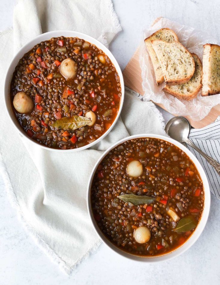 two bowls of lentil soup in white bowls with toasted bread.