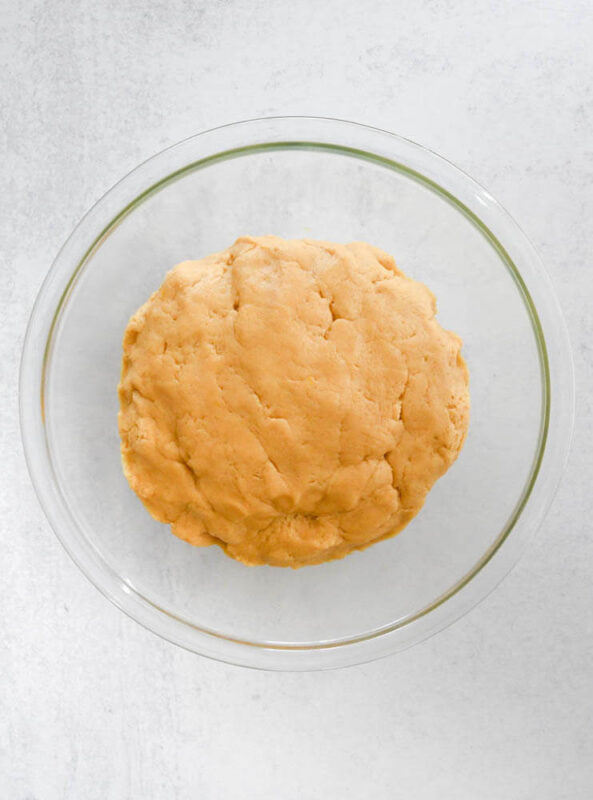 Koulourakia cookie dough in a large clear bowl.