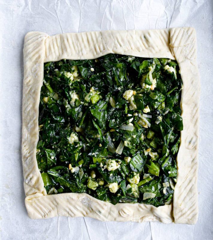 uncooked spanakopita puff pastry in a square shape.