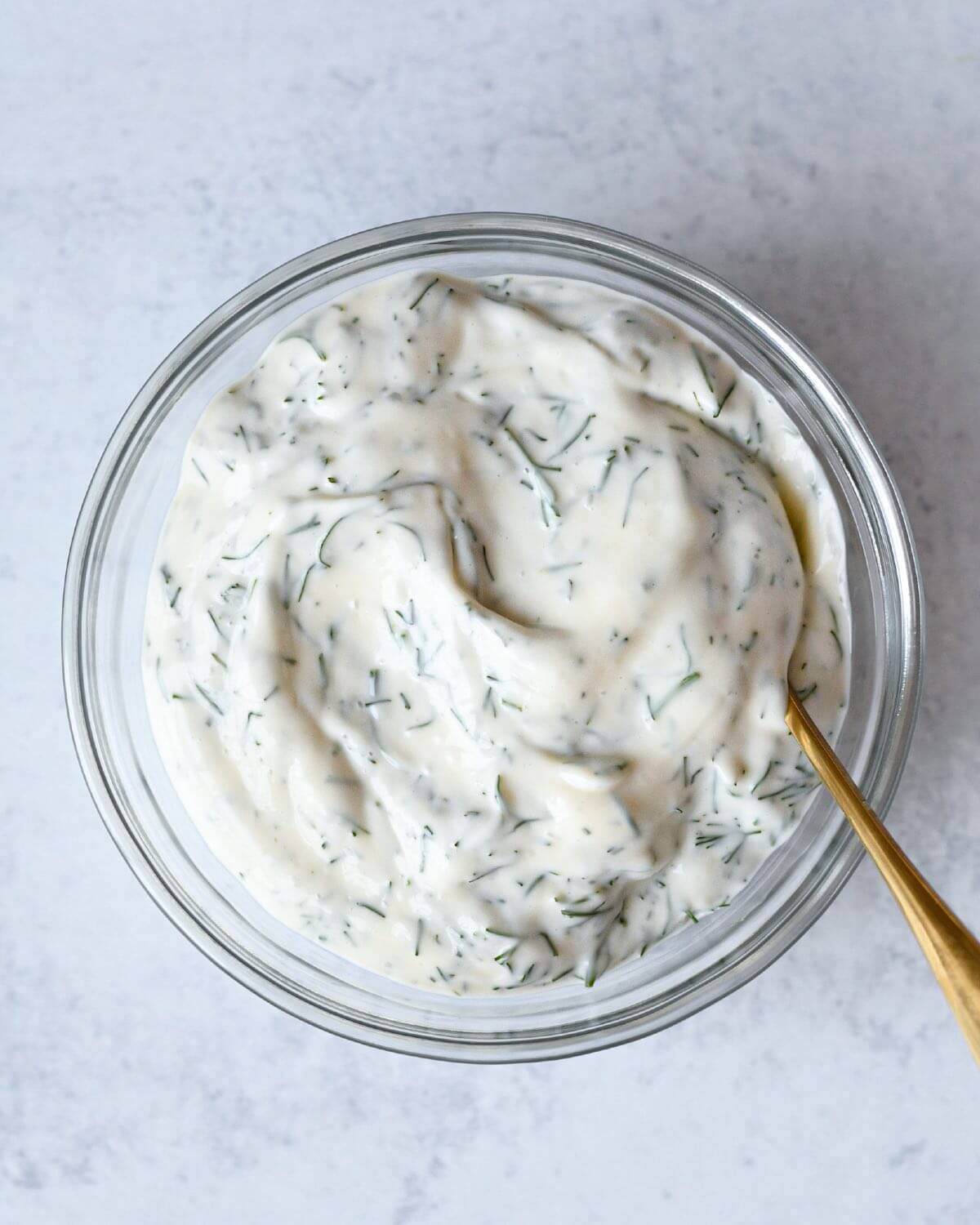 creamy dill mayo in a small round glass bowl.