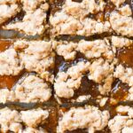 oatmeal fig jam bar squares with oat crumble on white parchment paper.