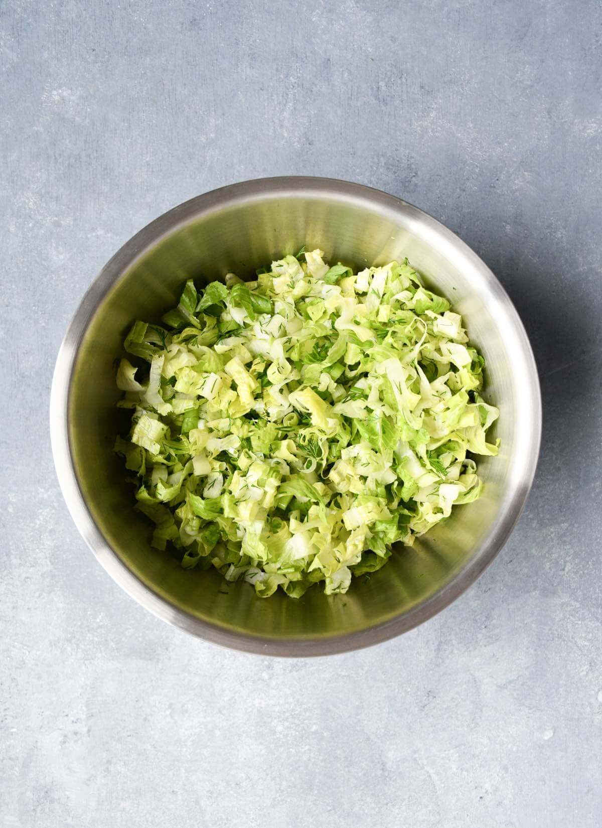 chopped romaine lettuce, green onions and fresh dill in a large bowl.